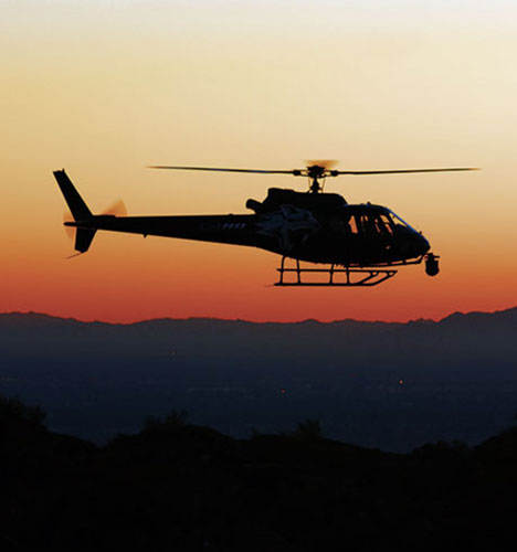 helicopter flying at sunset